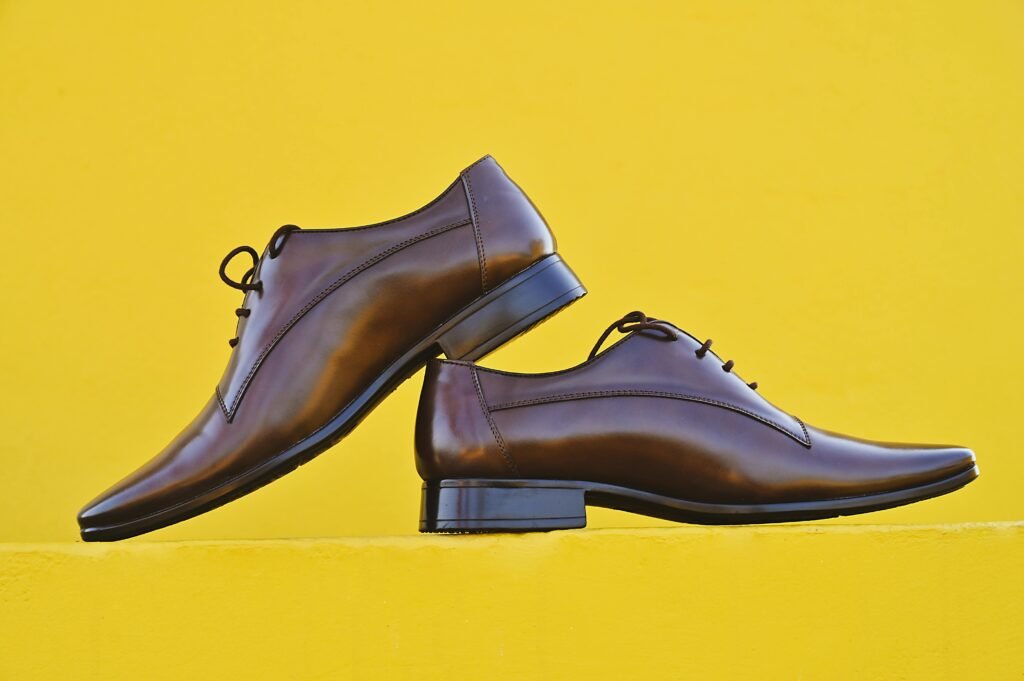 Stylish brown leather shoes displayed against a bright yellow background. Perfect for fashion and lifestyle themes.