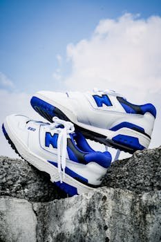 High-angle view of fashionable white and blue sneakers on a rock, outdoor setting.