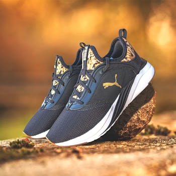 Elegant Puma sneakers showcased on a rock, perfect for outdoor sports enthusiasts.